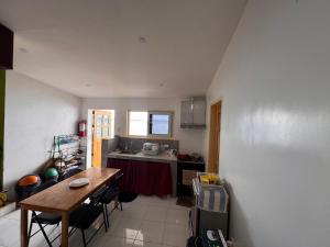 a kitchen with a wooden table and a table and chairs at Ellen Homestay in San Juan