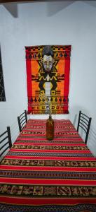 a table with a table cloth with a painting on the wall at Lalck Cketi Hotelería y Turismo in San Pedro de Atacama