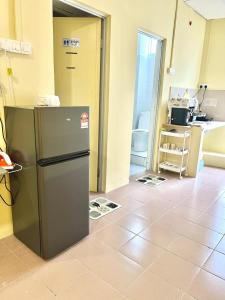 a kitchen with a refrigerator in the middle of a room at Camp Fire Homestay 2602 in Mersing
