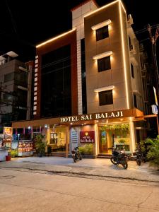 a hotel with motorcycles parked in front of a building at Hotel Sai Balaji in Shirdi