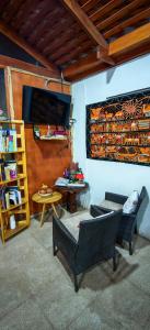 a living room with chairs and a table and a tv at Lalck Cketi Hotelería y Turismo in San Pedro de Atacama