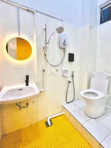 a bathroom with a toilet and a sink at Camp Fire Homestay 2602 in Mersing