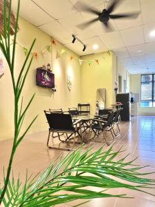 a dining room with tables and chairs and a plant at Camp Fire Homestay 2602 in Mersing