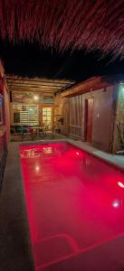 a swimming pool with red lights in a house at Lalck Cketi Hotelería y Turismo in San Pedro de Atacama
