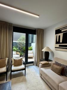 a living room with a couch and chairs and a window at Casa Amayuma - Málaga Centro Histórico in Málaga