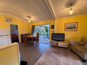 a living room with a couch and a tv and a table at Flat Hills Tourist Park in Ruahine