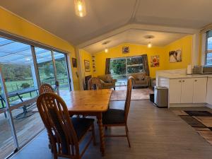 a kitchen and dining room with a wooden table and chairs at Flat Hills Tourist Park in Ruahine