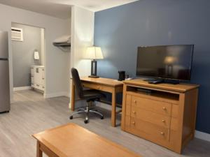 an office with a desk with a television and a chair at Rimbey Motor Inn in Rimbey