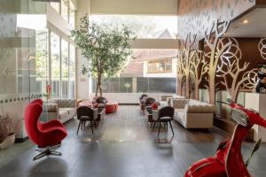a lobby with couches and chairs and a tree mural at Kalya Hotel Bandung Dago in Bandung
