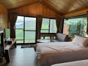 a bedroom with two beds and a couch and windows at Mo Huai Su-桃園市民宿085號 in Hualing