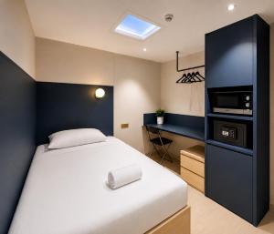 a bedroom with a bed with a microwave and a desk at ISA Hotel Amber Road in Singapore