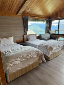 two beds in a room with mountains in the background at Mo Huai Su-桃園市民宿085號 in Hualing
