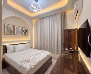 a bedroom with a bed and a flat screen tv at Maravia downtown hotel in Cairo