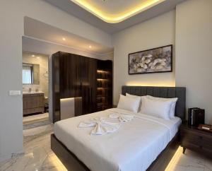a bedroom with a large white bed and a bathroom at Maravia downtown hotel in Cairo