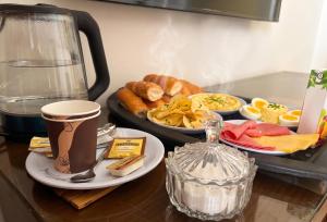 a table with a tray of breakfast foods and a coffee maker at Maravia downtown hotel in Cairo