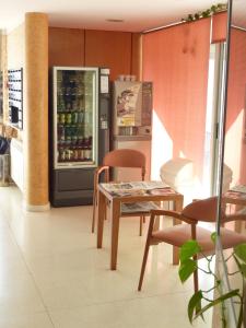 cocina con nevera, mesa y sillas en Hostal Residencia Batuecas, en Salamanca