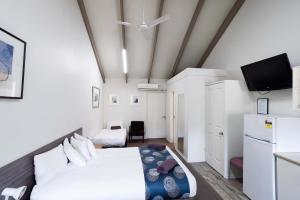 a bedroom with a bed and a flat screen tv at Canberra Ave Villas in Queanbeyan