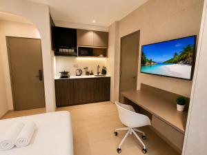 a room with a desk and a tv on a wall at ISA Hotel Amber Road in Singapore