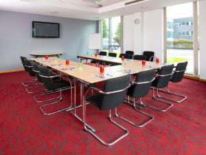 a conference room with tables and chairs on a red carpet at ibis Styles Haydock in Haydock