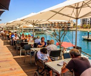 a group of people sitting at tables on a deck at Budget Friendly Accommodation in Mandurah