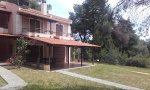 een huis met een veranda en een grasveld bij Sithonia Alekos Luxury Experience in Metamorfosi