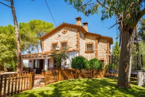 a house with a wooden fence in front of a yard at Luxury Villa El Turo in Castellví de Rosanés