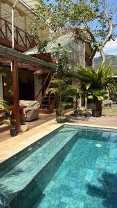 a swimming pool in front of a house at Jessies Beach House in Pulau Lutung