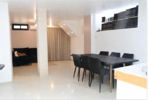 a dining room with a black table and black chairs at חדשה בעתיקה - צפת in Safed