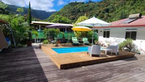 a house with a wooden deck and a swimming pool at Sweet little house - private pool in Punaauia