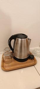 a tea kettle on a wooden tray on a counter at Hotel Seri Nilai in Nilai