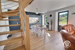 a kitchen and dining room with a table and stairs at Ty prad in Lanvellec