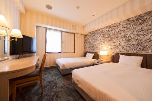 a hotel room with two beds and a desk at Hotel Global View Hachinohe Annex in Hachinohe +38 photos