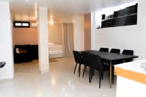 a dining room with a black table and black chairs at חדשה בעתיקה - צפת in Safed