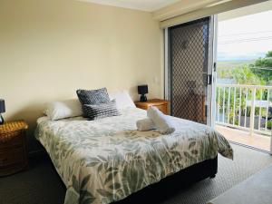 a bedroom with a bed and a balcony at Horizons At Peregian in Peregian Beach +47 photos