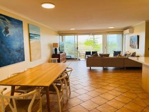 a living room with a table and a couch at Horizons At Peregian in Peregian Beach