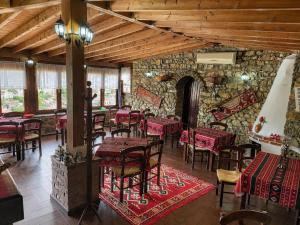 a restaurant with tables and chairs and a stone wall at Guva Mangalem Boutique Hotel & Restaurant -Berat Old Town View in Berat +45 photos