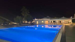 a large swimming pool with blue lighting in front of a building at Suntara Wellness Resort & Hotel in Chachoengsao
