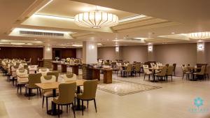a restaurant with tables and chairs in a room at Suntara Wellness Resort & Hotel in Chachoengsao