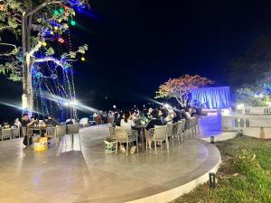 a group of people sitting at tables at night at Suntara Wellness Resort & Hotel in Chachoengsao +63 photos
