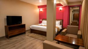 a hotel room with a bed and a flat screen tv at Hotel Sai Kripa, sikkim in Ravangla