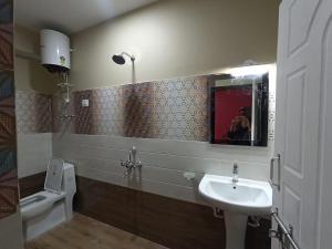 a bathroom with a sink and a toilet and a mirror at Hotel Sai Kripa, sikkim in Ravangla