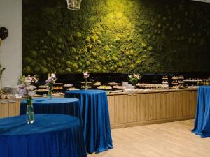 two tables with blue table cloths in front of a buffet at ibis Styles Bialystok in Białystok