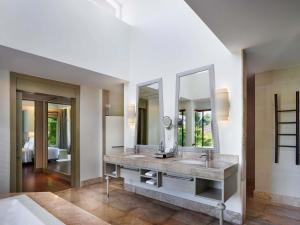 a bathroom with two sinks and a large mirror at Pullman Phuket Panwa Beach Resort in Panwa Beach