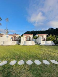 a group of rocks in the grass in front of a house at Garden Hill Kintamani with Natural Hot Springs in Kubupenlokan