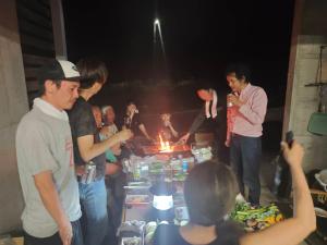 a group of people standing around a table with a fire at 天水島ヒルズ in Tokamachi