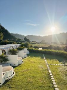a view of a yard with white buildings and grass at Garden Hill Kintamani with Natural Hot Springs in Kubupenlokan