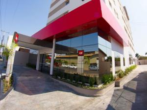 a building with a parking lot with cars in the windows at ibis Catalao in Catalão