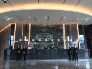 um grupo de homens de fato em pé em um lobby em 綺麗商旅園區館 em Taitung City