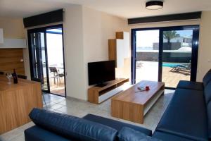 a living room with a blue couch and a tv at Villas Coloradas in Playa Blanca