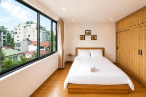 a bedroom with a bed and a large window at 22Housing luxury Hotel & Residence 39 Linh Lang in Hanoi +103 photos